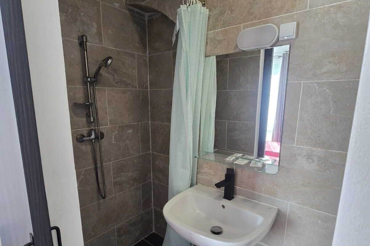 Une salle de bain avec une douche, un lavabo et des toilettes.