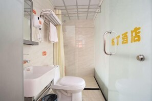 A bathroom with a toilet, sink, and shower.