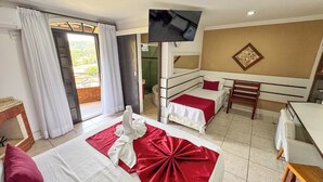 A hotel room with two beds, a TV, a small desk, and a view of the outdoors. - Hotel do Papai Noel  (Itatiaia)