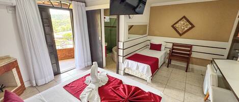 Habitación de hotel con dos camas, televisión, un escritorio pequeño y vistas al exterior.