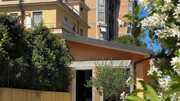 A courtyard with two wicker chairs, a small table, and a building entrance. - Two-room apartment with private garden 4 km from Marmore Falls. (Terni)
