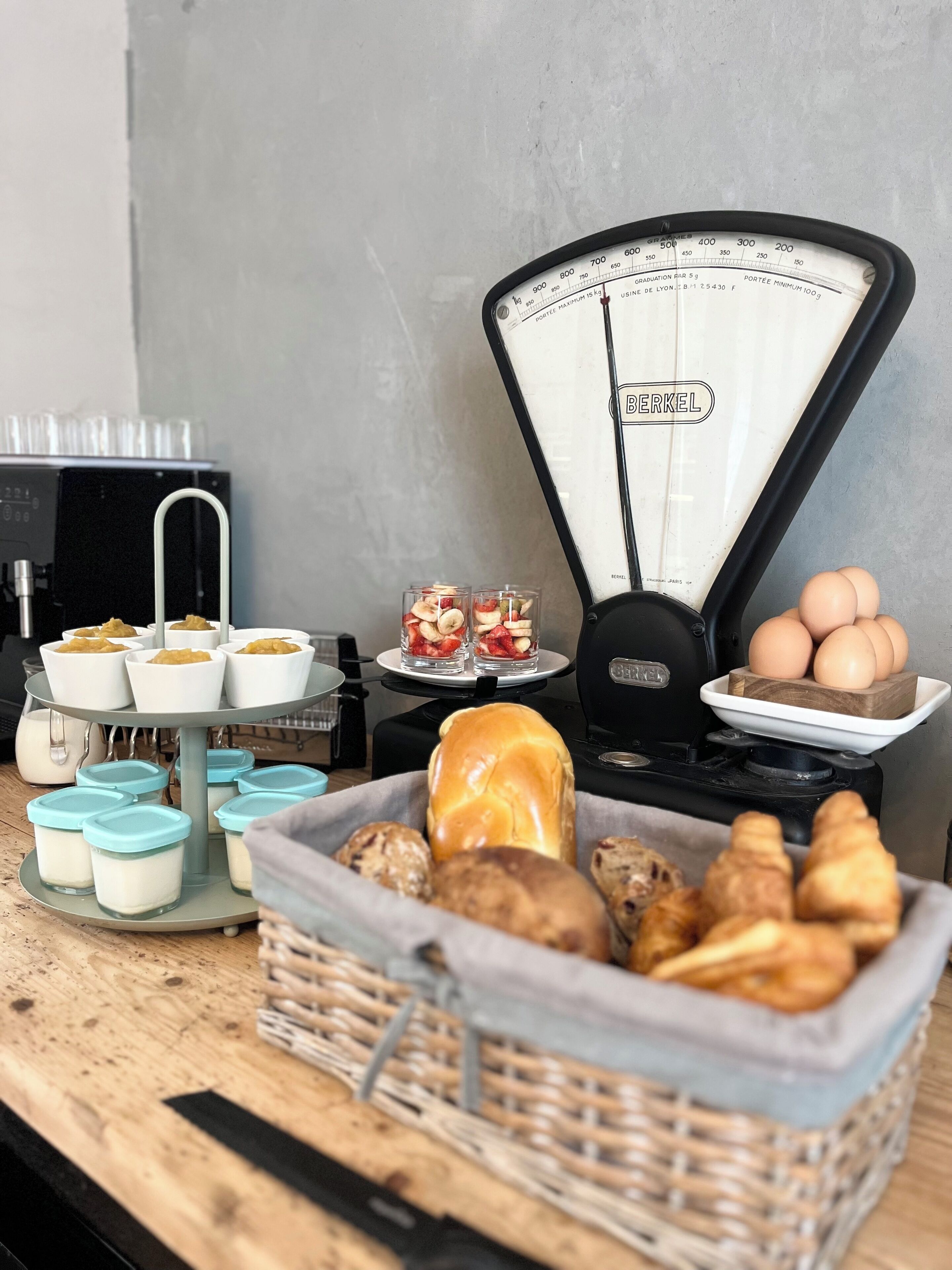 Un bufé de desayuno con diversas opciones de comida, incluyendo pasteles, pan y recipientes con yogur o crema.