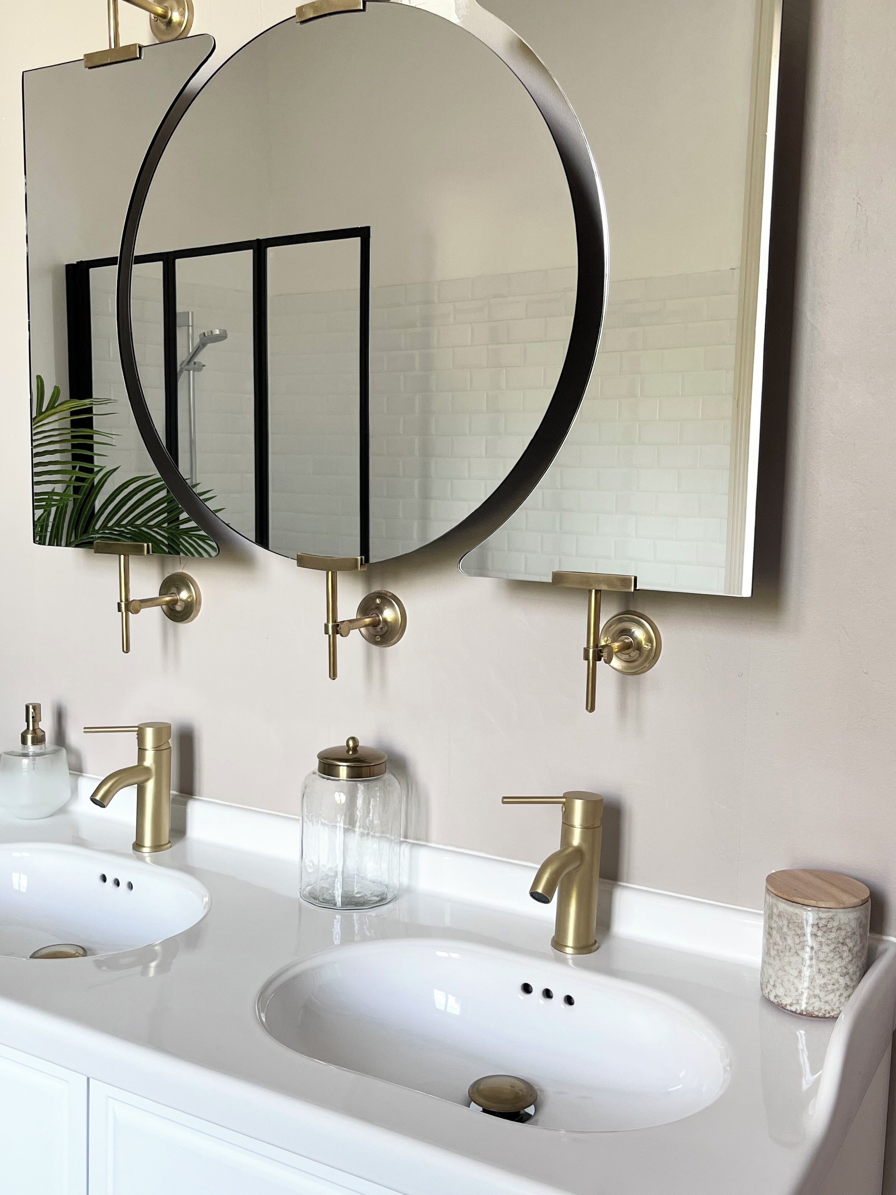 A bathroom with two sinks, a large mirror, and a shower.