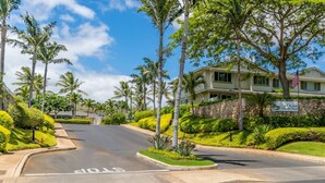 A residential area with a house named "Ko Olina" and a stop sign on the road.