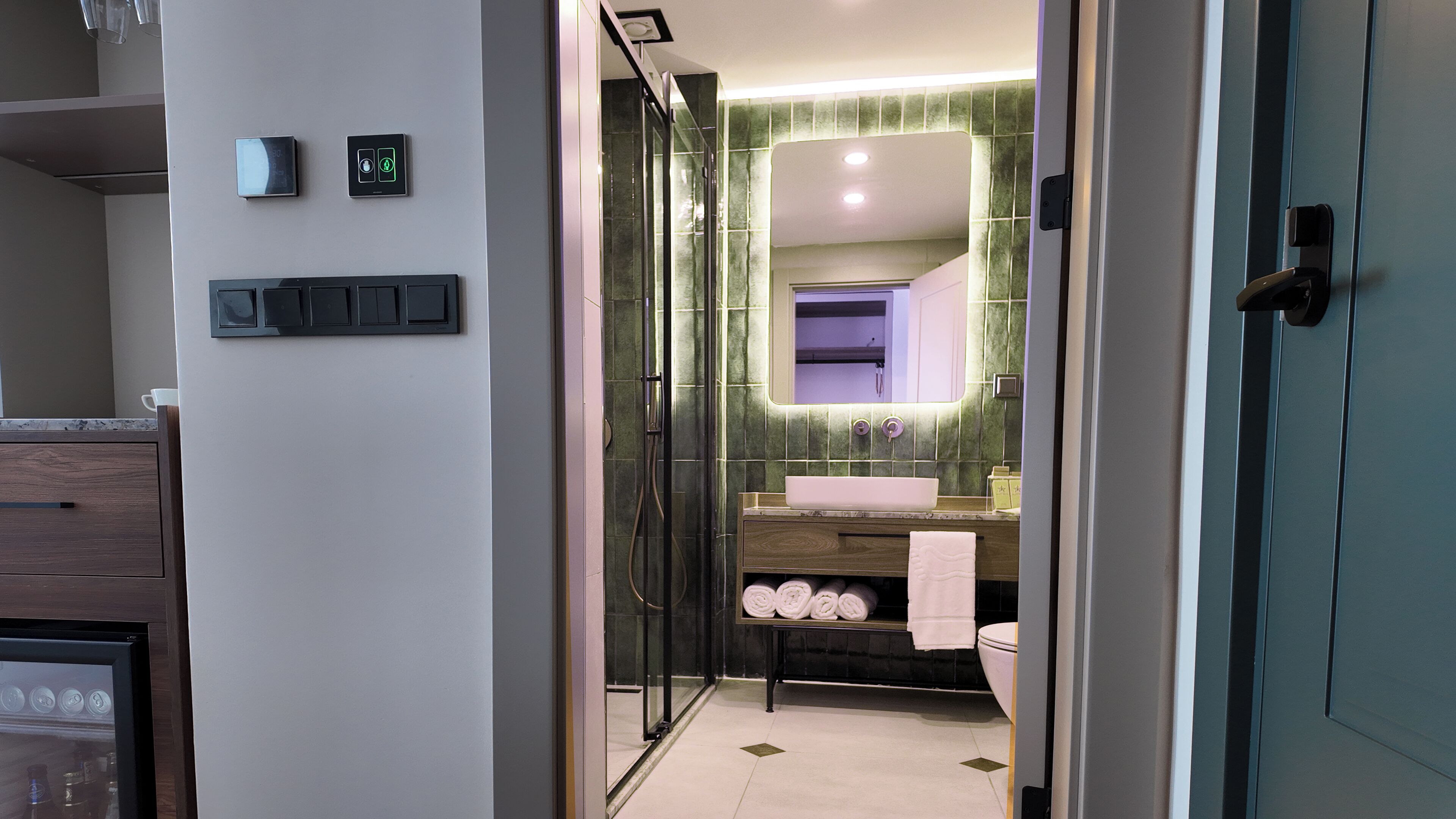 Une salle de bain moderne avec une douche à parois de verre, un meuble-lavabo doté d’un grand miroir et des toilettes.
