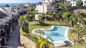 Ein Resort mit Swimmingpool, umgeben von Palmen und Blick auf den Ozean.