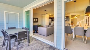 An open-plan living and dining area with a kitchen visible through an open doorway.