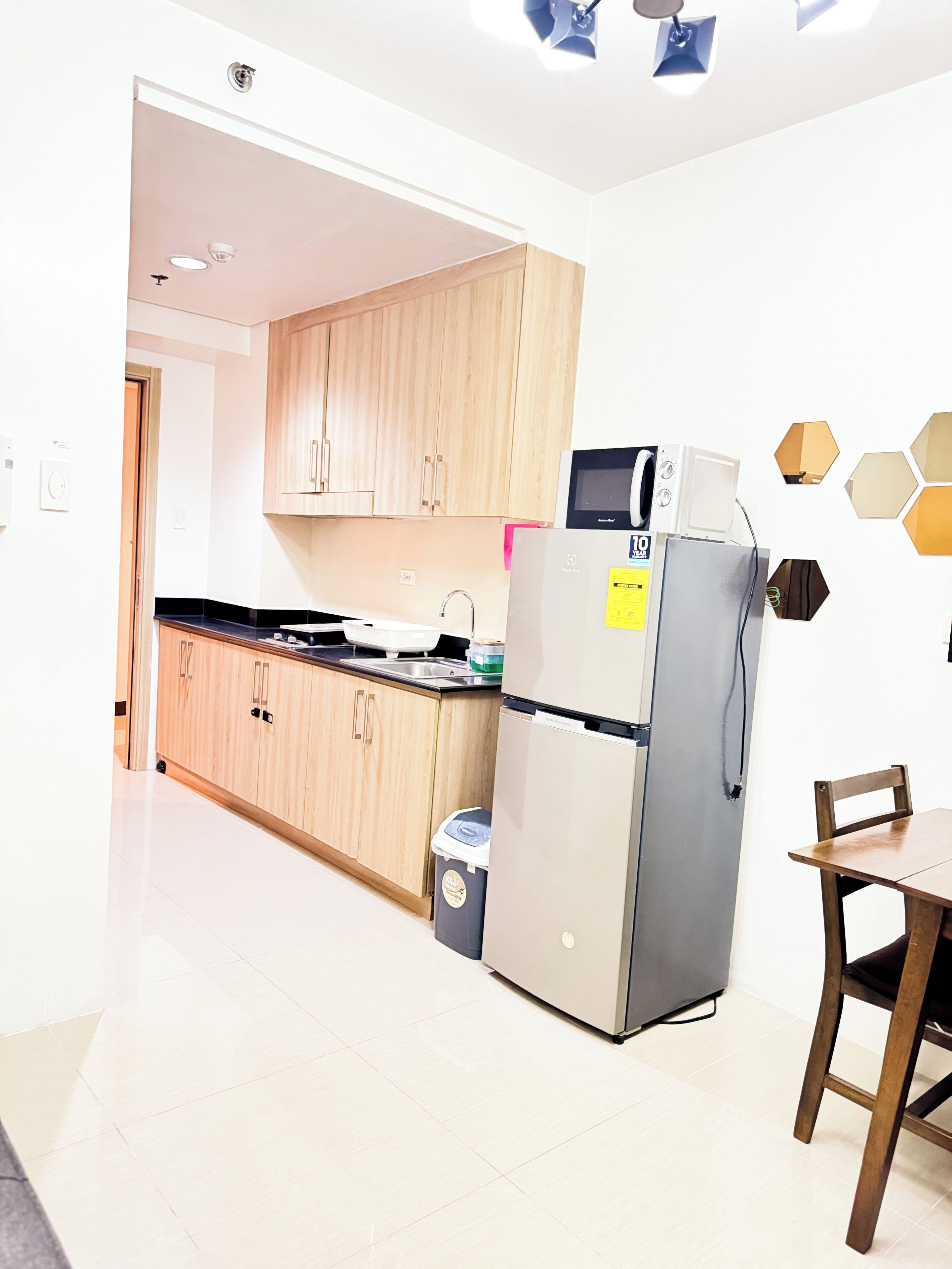 Une cuisine moderne avec des meubles en bois, un réfrigérateur en acier inoxydable, un four à micro-ondes et un évier.