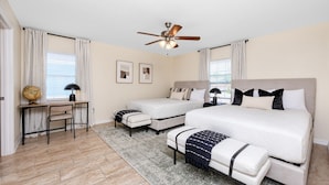 A bedroom with a large bed, two smaller beds, a desk, and a globe. - Summer Safari - GORGEOUS Home Near Busch Gardens & USF (Tampa)