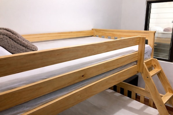 A bunk bed with a wooden frame and a mattress.