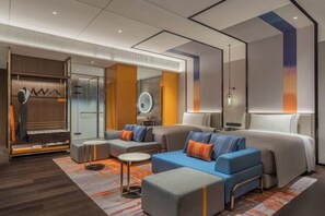 A modern hotel room with a large bed, two sofas, a small table, and a walk-in closet. - Canopy by Hilton Xi'an Qujiang (Xi'an)