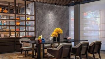 A dining area with a glass table, chairs, and a decorative vase.