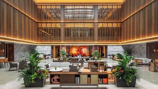 A spacious lobby with a central reception desk, seating areas, and a large mural on the back wall. - Canopy by Hilton Xi'an Qujiang (Xi'an)