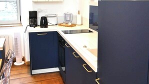 A modern kitchen with a microwave, coffee maker, and a sink.
