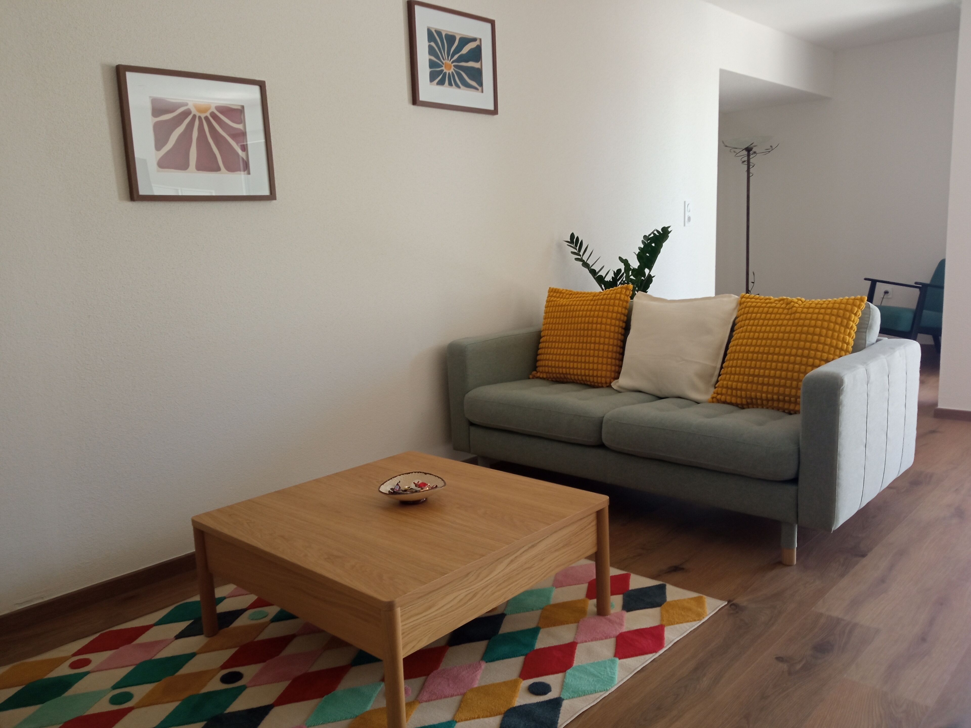 Ein Wohnzimmer mit einer Couch, einem Couchtisch und einem gemusterten Teppich.