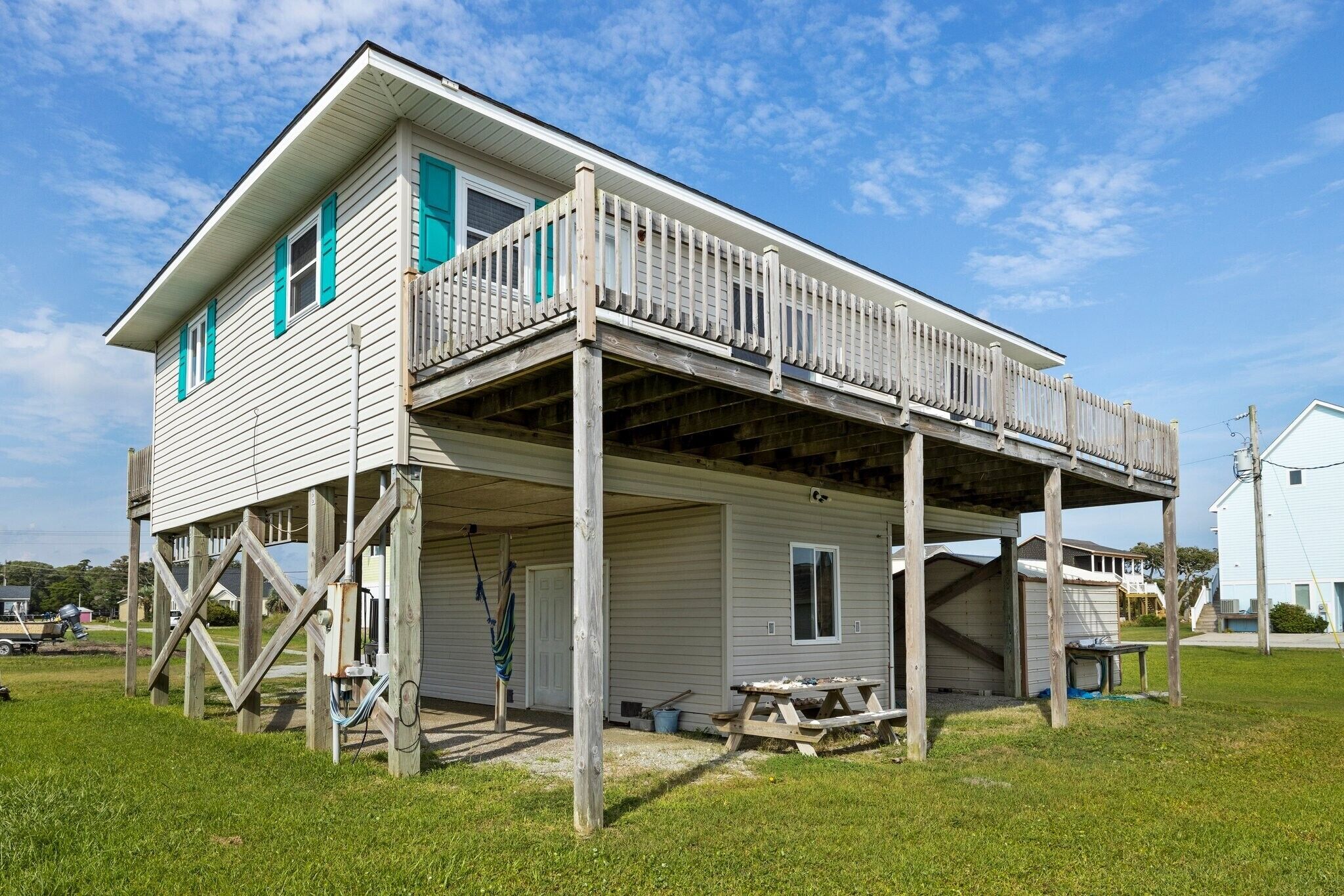 A two-story house with a wooden deck and a covered porch.