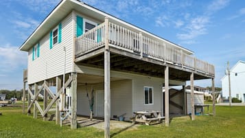 A two-story house with a wooden deck and a covered porch.