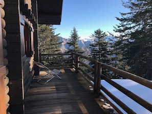 A wooden deck with a view of snow-covered mountains and pine trees. - "LES RONDINS, Guzet snow chalet, direct start to slopes and hikes, panoramic view (Ustou)