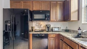 A kitchen with wooden cabinets, a black refrigerator, a microwave, a coffee maker, a toaster, and a dishwasher. - Private Entry Guest Suite by AZ Athletic Grounds - 1 BD + 1 BA - Sleeps 4 (Mesa)
