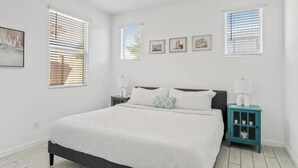 A bedroom with a large bed, two bedside tables, a ceiling fan, and three windows with blinds. - Private Entry Guest Suite by AZ Athletic Grounds - 1 BD + 1 BA - Sleeps 4 (Mesa)