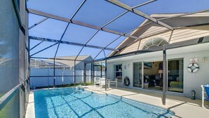 En swimmingpool med en glasvägg runt om, en täckt uteplats och en livboj på väggen.