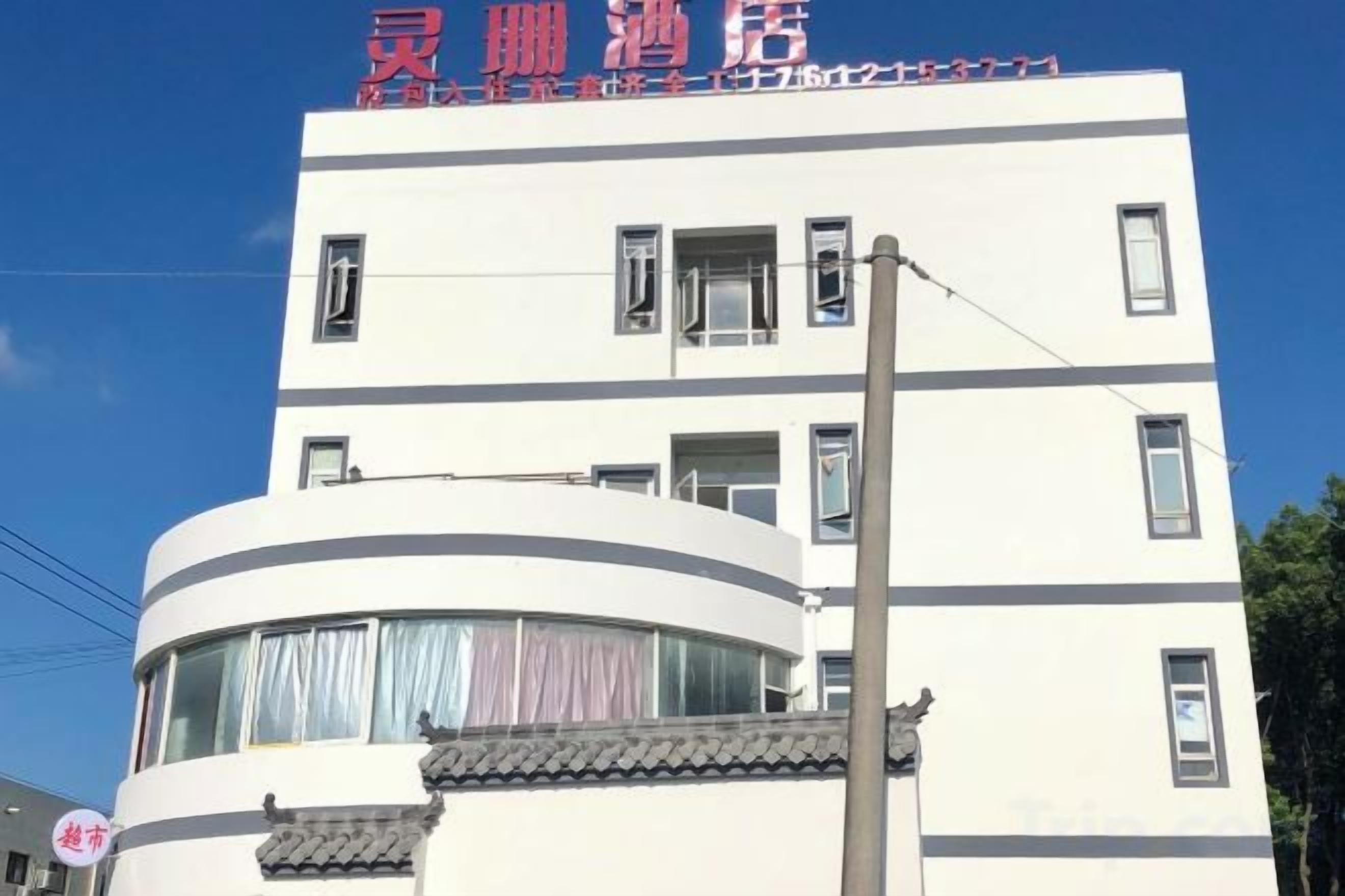 Un edificio de varios pisos con una sección curva, múltiples ventanas y un balcón visible.