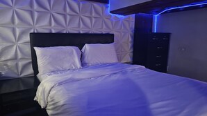 A neatly made bed with white linens in a room with a textured white wall and a black headboard. - Lofty Cozy Suite near Nassau Coliseum and Hofstra University (Hempstead)