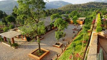 A courtyard with pavilions, trees, and a view of mountains.