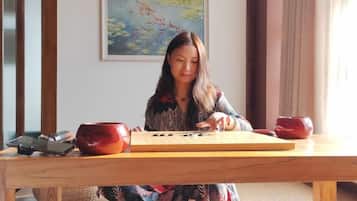 Una persona sentada a una mesa de madera con un teclado y dos cuencos rojos.
