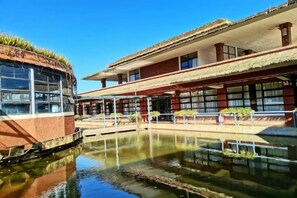 Un bâtiment doté d’une cour intérieure et d’un élément décoratif aquatique réfléchissant.