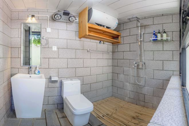 Ein kleines Badezimmer mit Toilette, Waschbecken und Dusche.