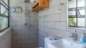 Ein Badezimmer mit Dusche, Waschbecken und einem Fenster mit Blick.