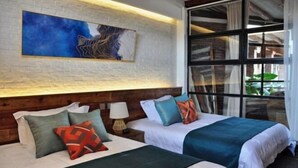 Ein Hotelzimmer mit zwei Betten, einem großen Fenster, einem Gemälde an der Wand und einem hölzernen Kopfteil.