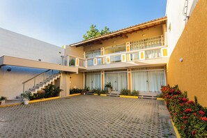 Un edificio de dos pisos con un patio, una escalera y un balcón.