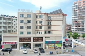 Un edificio de varios pisos con locales comerciales en la planta baja, incluyendo un restaurante y una tienda.