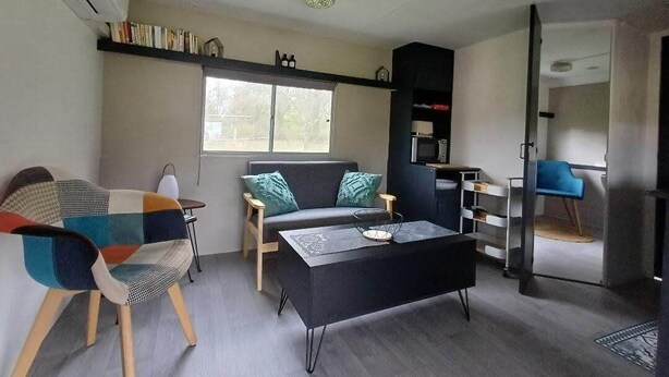 Una sala moderna con un sofá, una mesa de centro y una estantería.