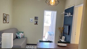 A modern kitchen with a black countertop, a ceiling fan, and a pendant light. - Centro da cidade tudo a pé (Cabo Frio)