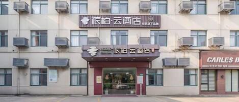 A hotel with a sign indicating it is a 'Yuan Hotel' and a 'Carles Bar' adjacent to it.