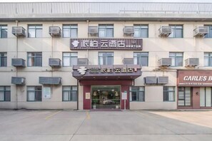 A hotel with a sign indicating it is a 'Yuan Hotel' and a 'Carles Bar' adjacent to it. - Pebble Motel (Shanghai Beidi Road) (Shanghai)