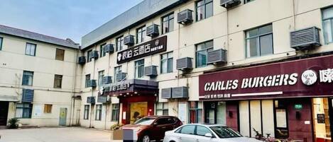 A multi-story building with commercial establishments on the ground floor, including a restaurant and a business with signage.