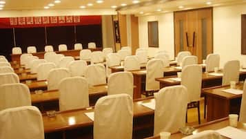 A conference room with rows of tables and chairs, equipped with nameplates and water bottles.