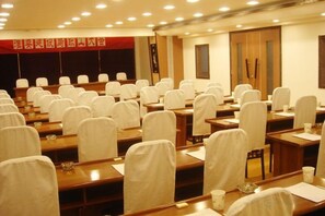A conference room with rows of tables and chairs, equipped with nameplates and water bottles. - Forest Coast Hotel Chain (Railway Station Zhucheng Hotel) (Bengbu)
