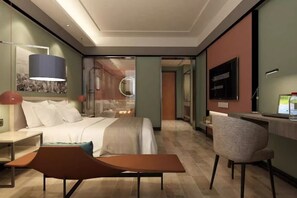 Une chambre d’hôtel moderne équipée d’un lit, d’un bureau, d’une chaise et d’un grand miroir.