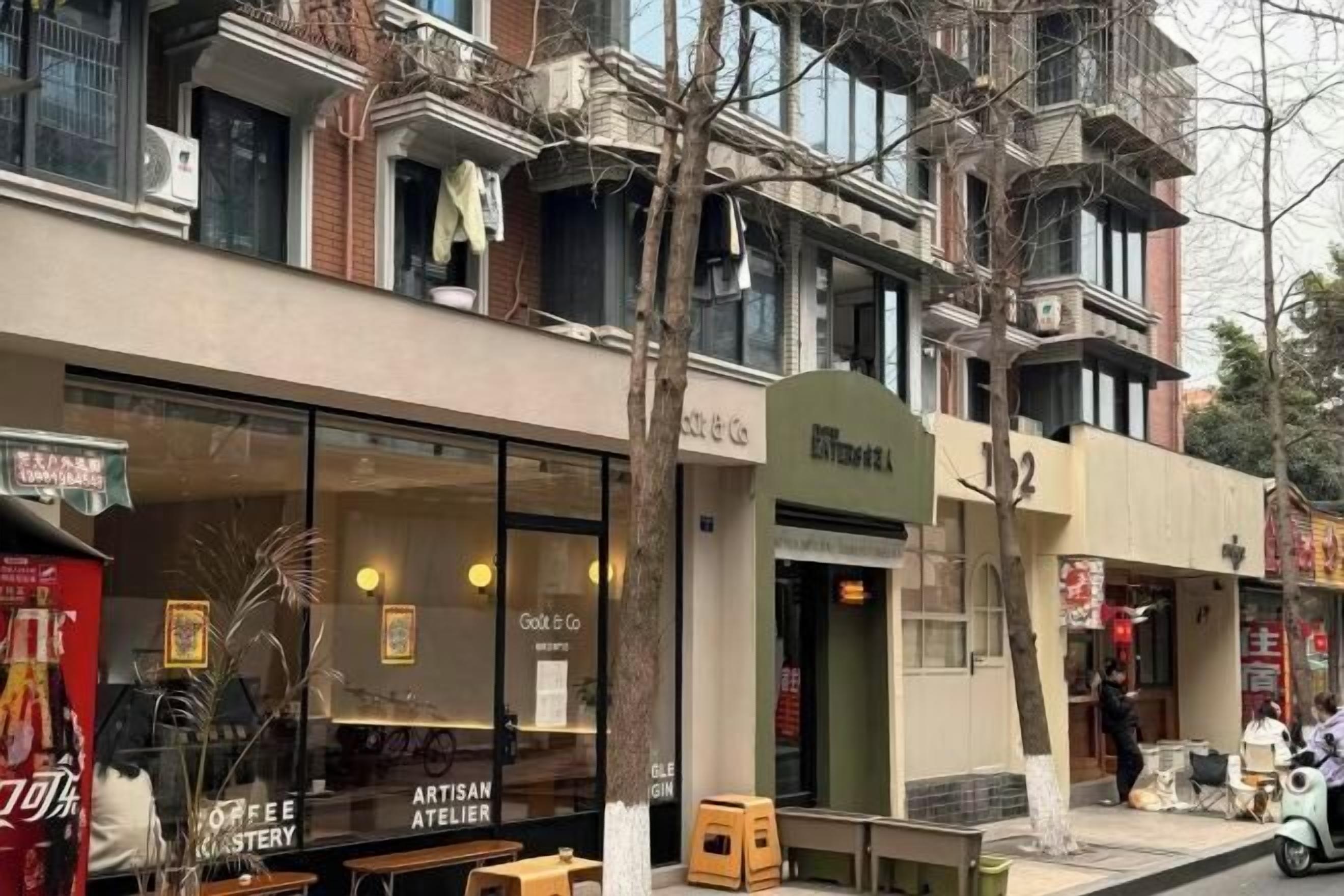 A street view with a coffee shop named 'Gout & Co' and a building with a green awning.