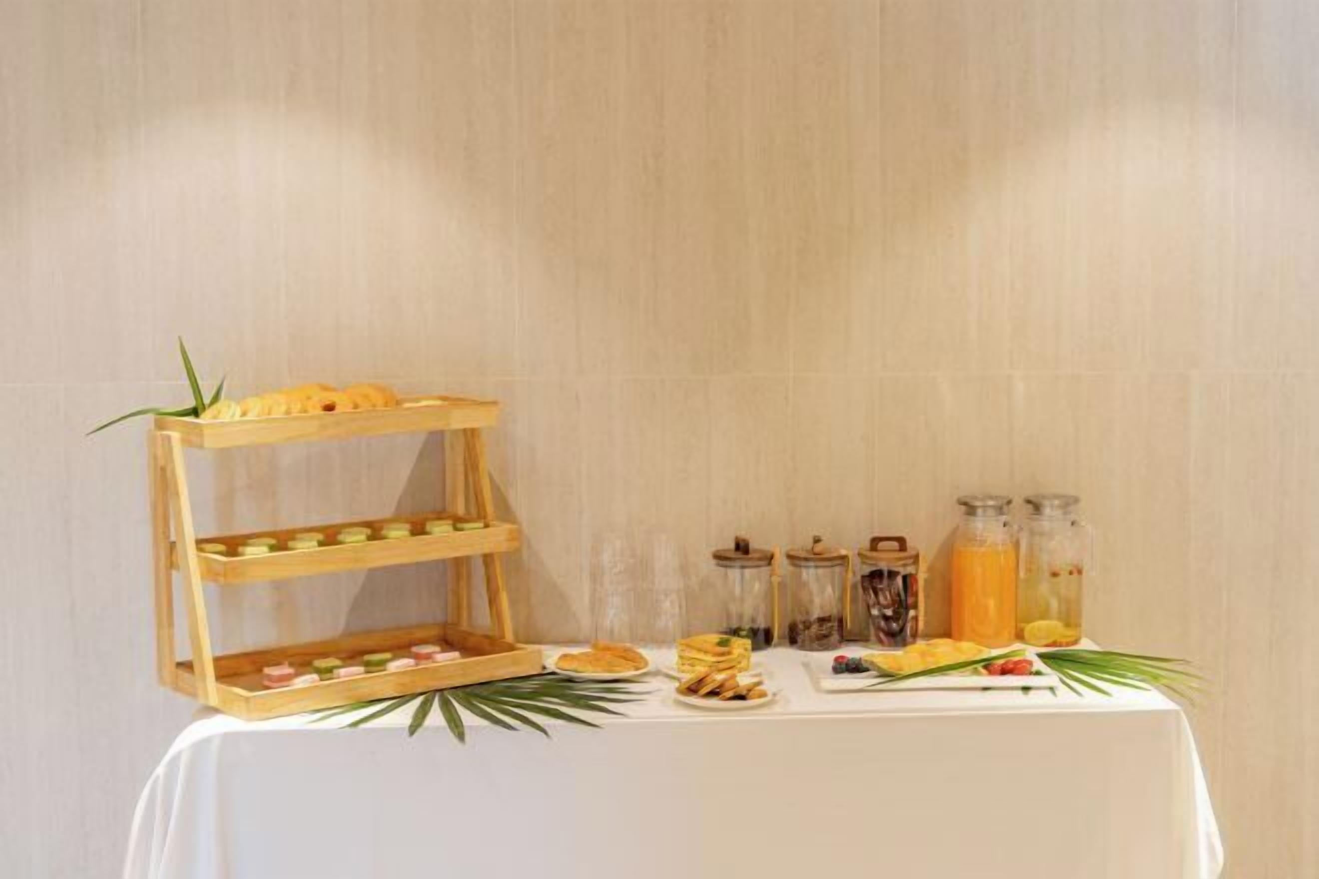 Aamiaistarjoilu on järjestetty buffet-tyyliin: ruokia on esillä puisen telineen päällä, mausteita on tarjolla purkeissa ja pöydällä on monenlaista syötävää.