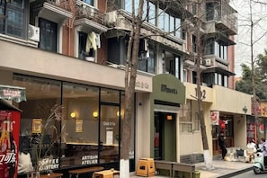 A building with a coffee shop on the ground floor and a restaurant above. - Cosy City Hotel (Chengdu South Railway Station Sichuan University Wangjiang Campus） (Chengdu)