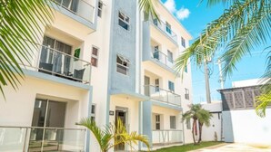 Un immeuble résidentiel à plusieurs étages, doté de balcons, d’un toit plat et surplombant un ciel dégagé.