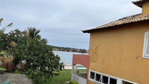 Un barrio residencial con vista a un cuerpo de agua, una casa de techo de tejas y un pequeño jardín.