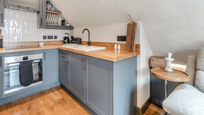 A modern kitchen with grey cabinets, a wooden countertop, and a small wooden table. - 2 bedroom accommodation in Narbeth (Narbeth)
