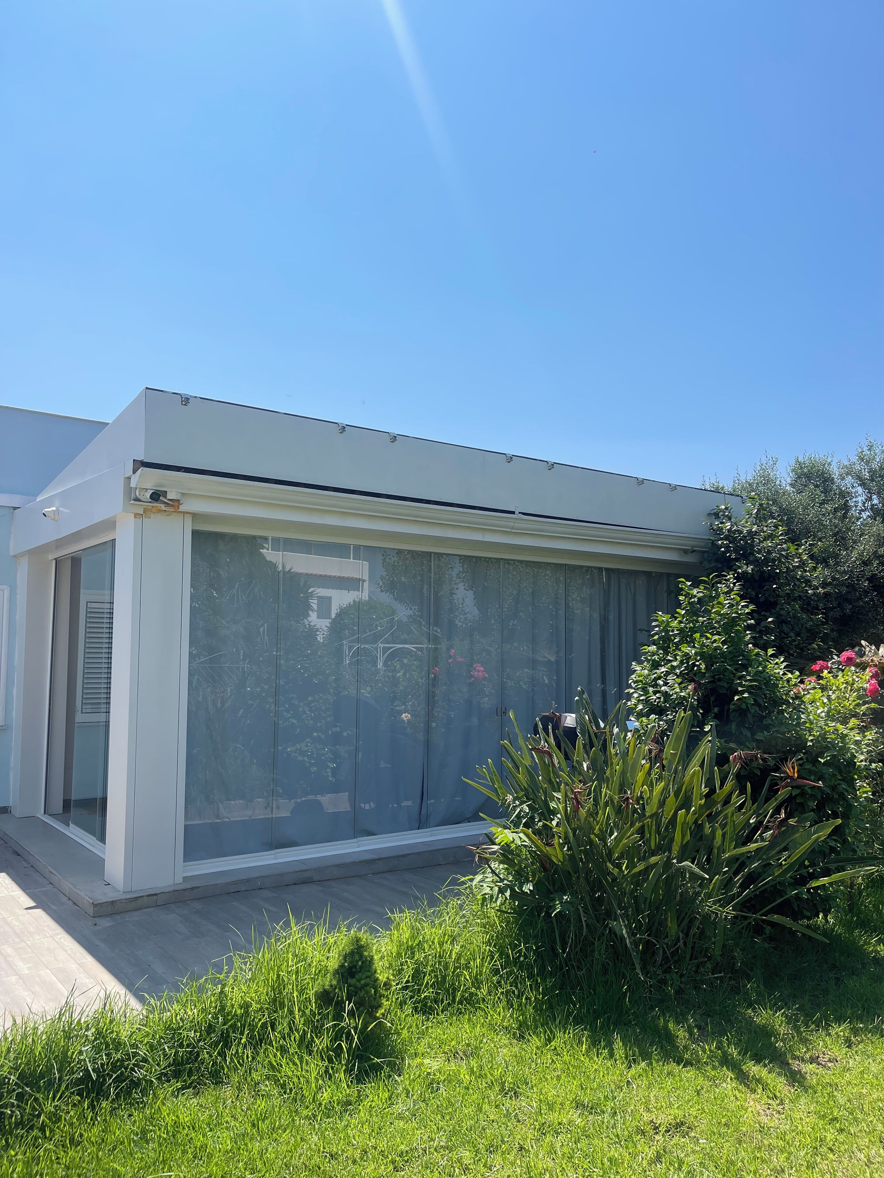 Un bâtiment moderne doté de grandes fenêtres en verre et d’un toit plat.